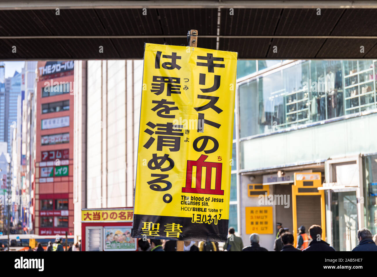 Schild mit Zitat aus der Bibel, die in Japanisch, "das Blut Jesu Christi reinigt Sünde', auf der Straße in Tokio Stockfoto