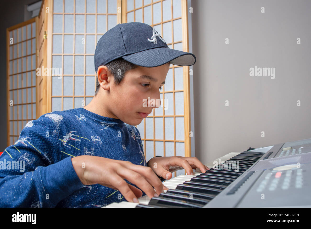 Junge, Alter 12, Lernen, Keyboard zu spielen Stockfoto