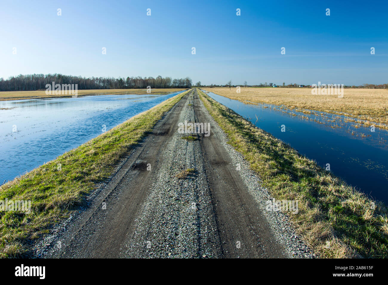 Schotterstraße und Wasser auf beiden Seiten Stockfoto