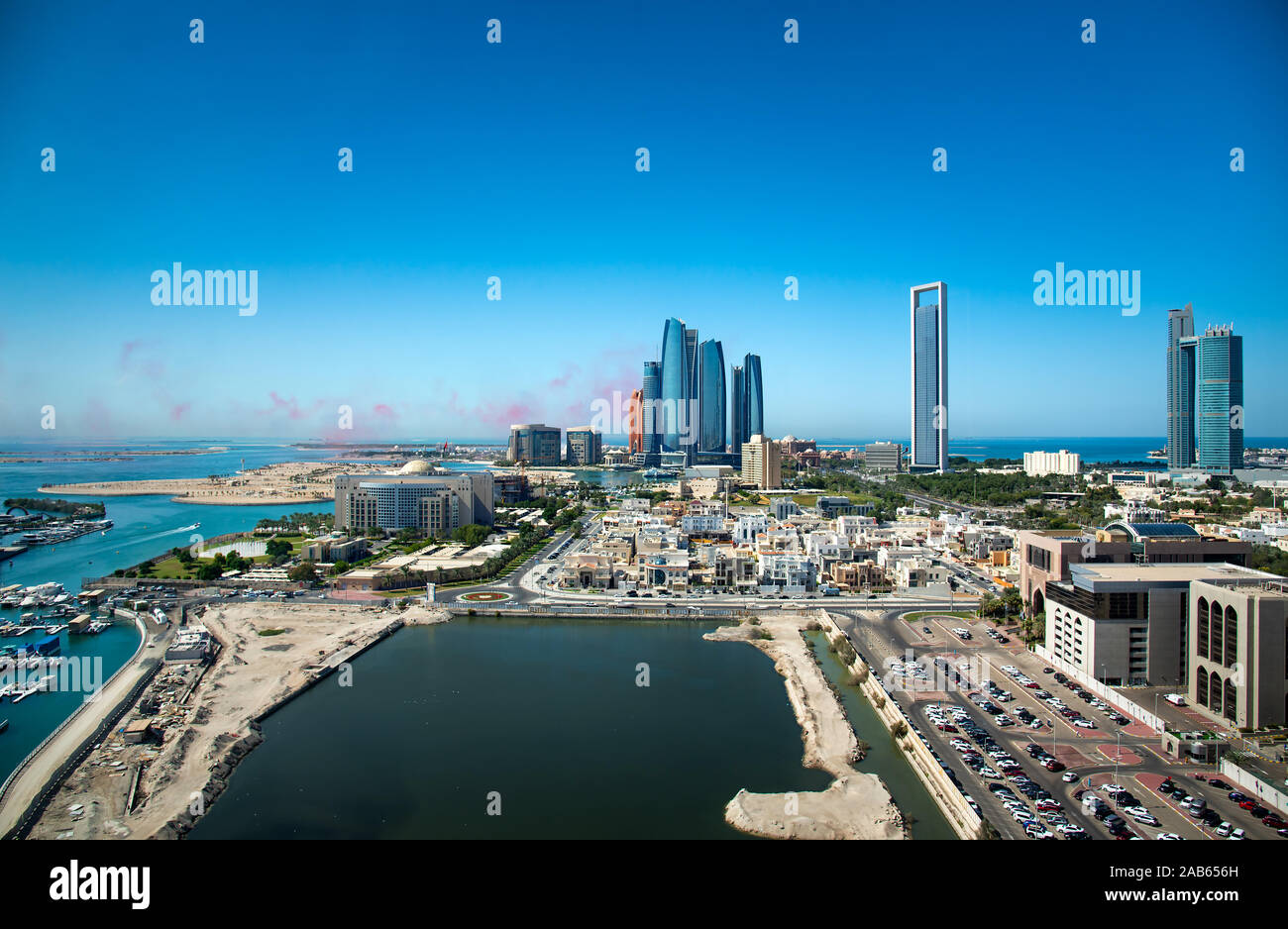 Abu Dhabi Skyline mit air show Farben in den Himmel und Blick auf die Innenstadt von modernen Gebäuden der VAE capito Stockfoto