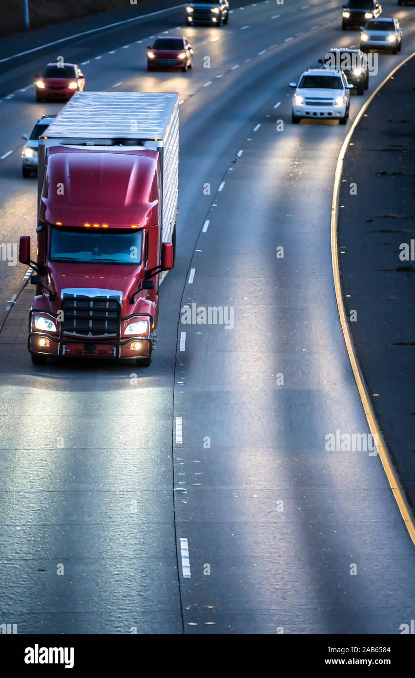 Dunkel Rot Big Rig Motorhaube American Semi Truck Transport von kommerziellen Ladung im Kühlschrank Auflieger, die auf der breiten Multilinien highway Stockfoto