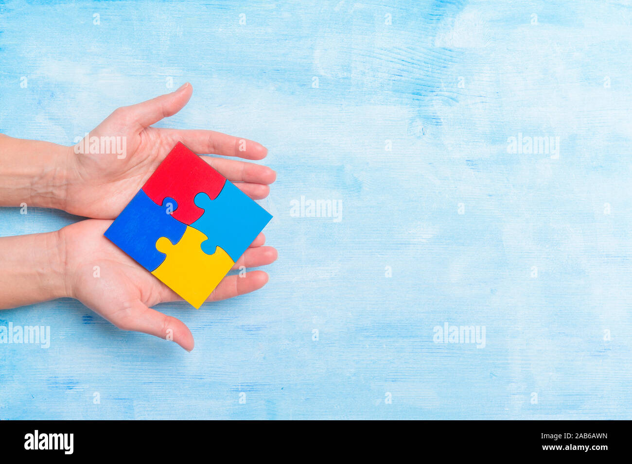 Hände spielen ein Puzzle Symbol der Sensibilisierung der Öffentlichkeit für Autismus Spektrum Störungen. Stockfoto