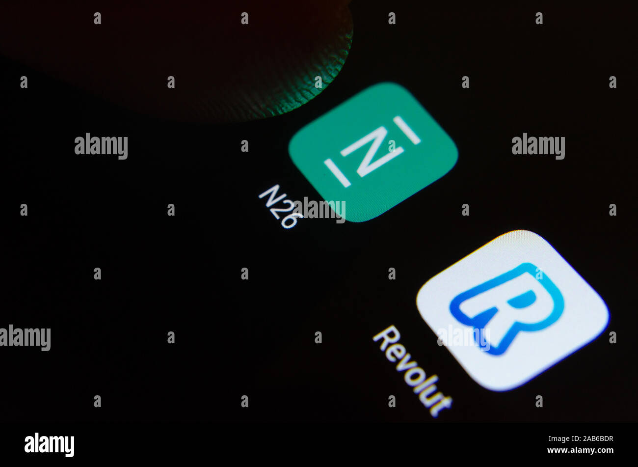 N 26 und Revolut Bank apps Logo auf dem Bildschirm angezeigt und mit einem Finger zu berühren. Konzept Foto für den Wettbewerb. Stockfoto