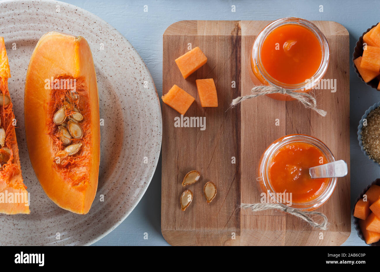 Bio Kürbis Marmelade im Glas Gläser auf dem grauen Hintergrund mit Kürbissen dekoriert. Herbst Rezepte, Gerichte aus einem Kürbis. Gesundes Essen. Flach. Stockfoto