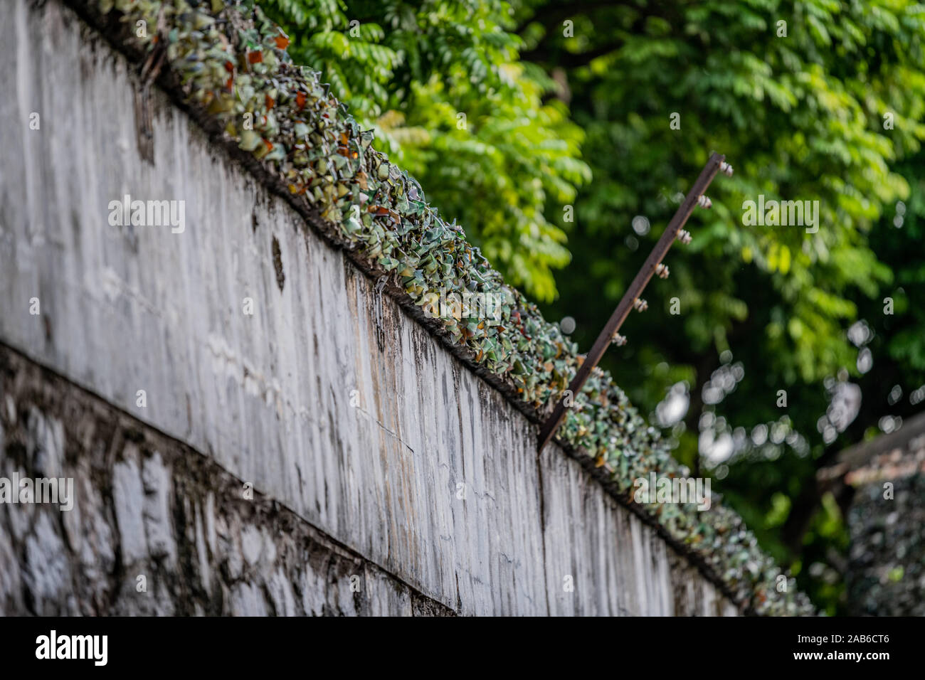 Zerschlagene Glasflaschen sind oben an einer Wand zu Gefangenen die Flucht aus der Hanoi Hotel politische Gefängnis in Vietnam verhindern klemmt Stockfoto