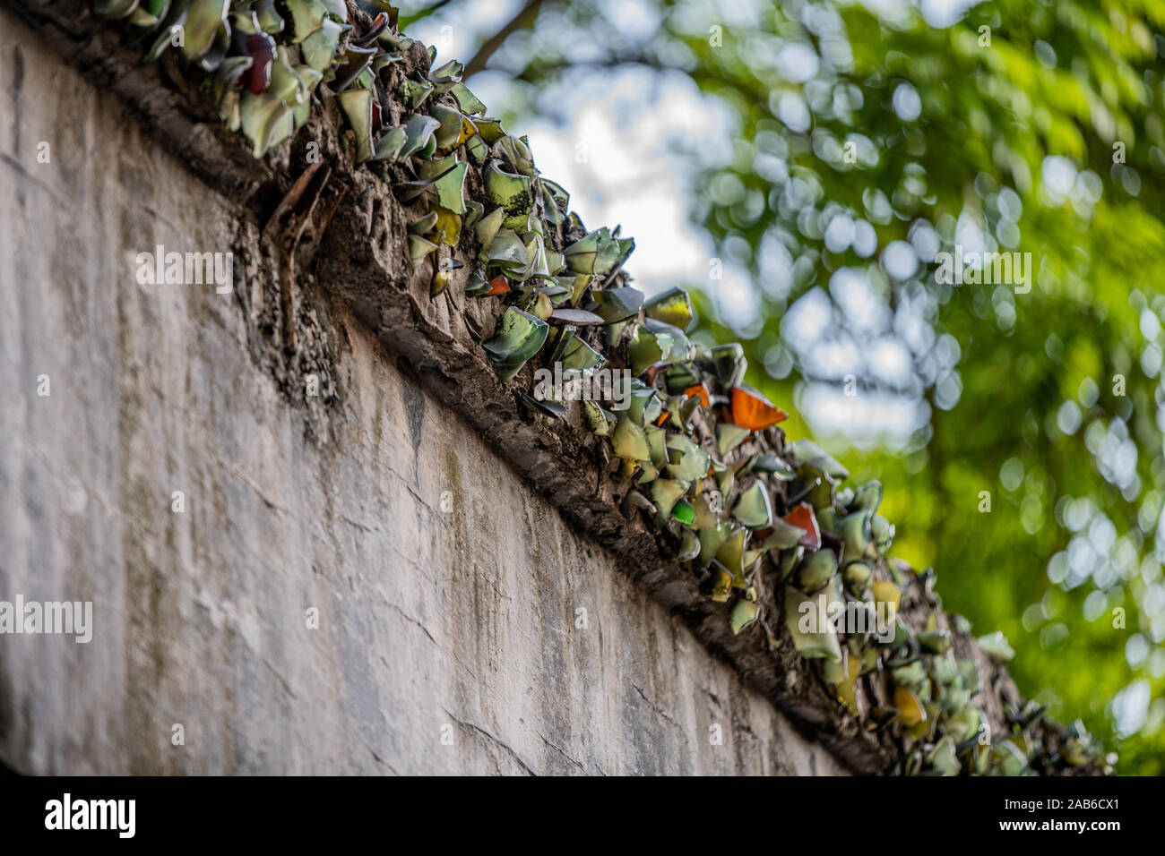Zerschlagene Glasflaschen sind oben an einer Wand zu Gefangenen die Flucht aus der Hanoi Hotel politische Gefängnis in Vietnam verhindern klemmt Stockfoto
