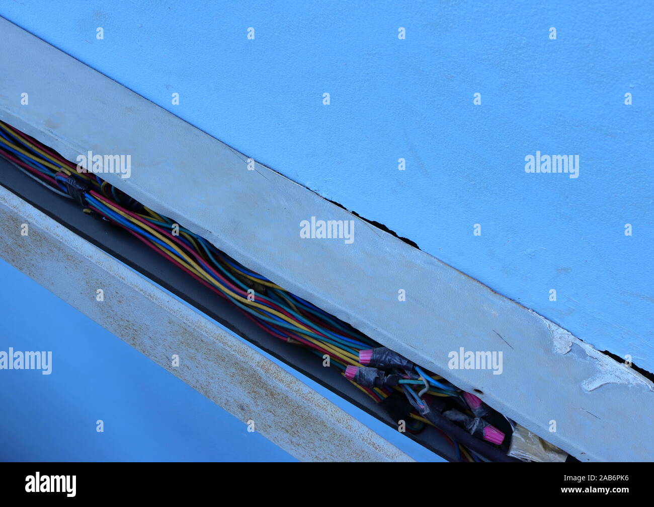 Closeup Gruppe von Stromleitungen innen gebrochen elektrischen Kabelkanal an der Wand eines Gebäudes installiert Stockfoto
