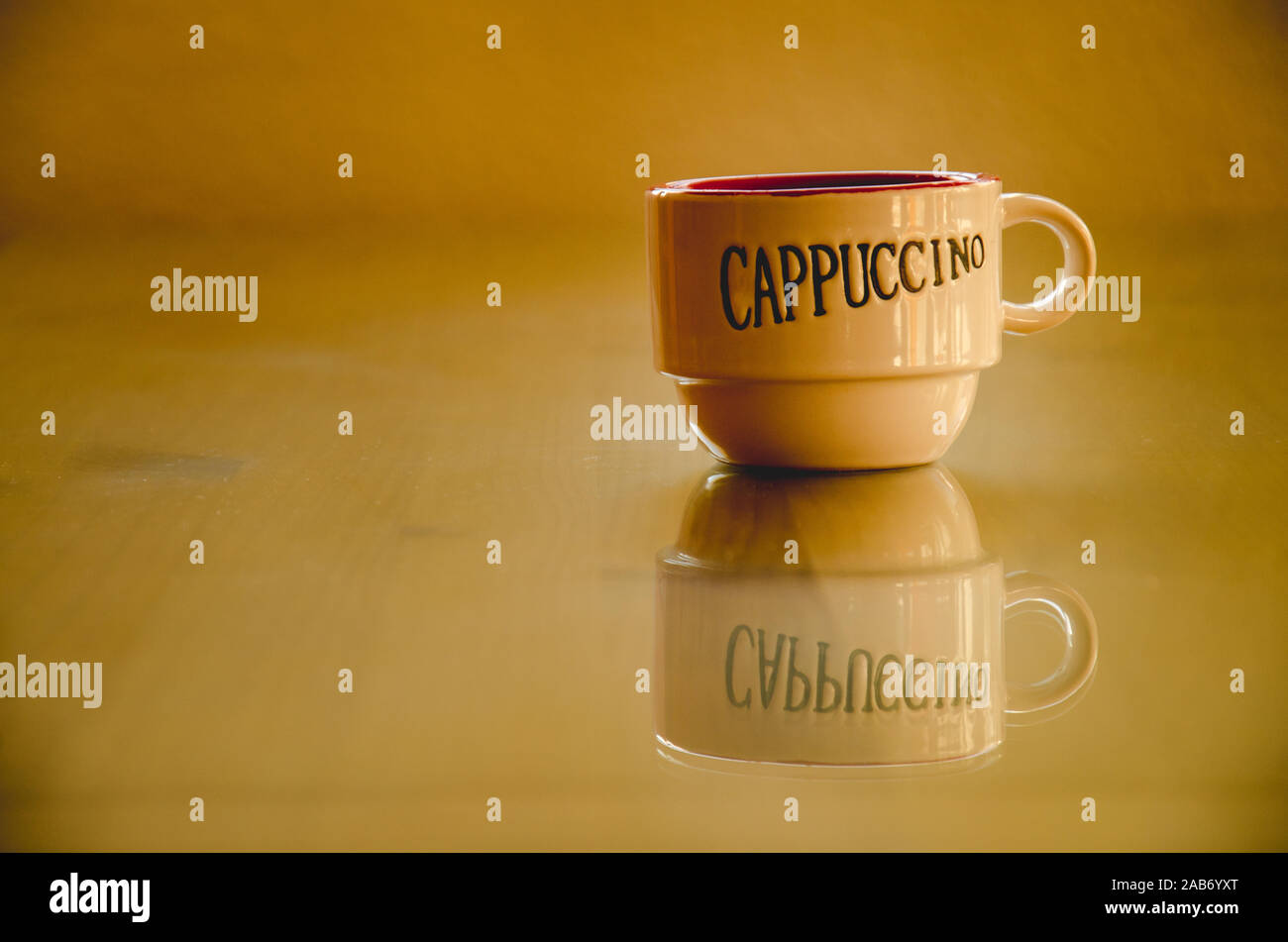 Eine Tasse leer Cappuccino auf einem Holztisch mit Glas Stockfoto