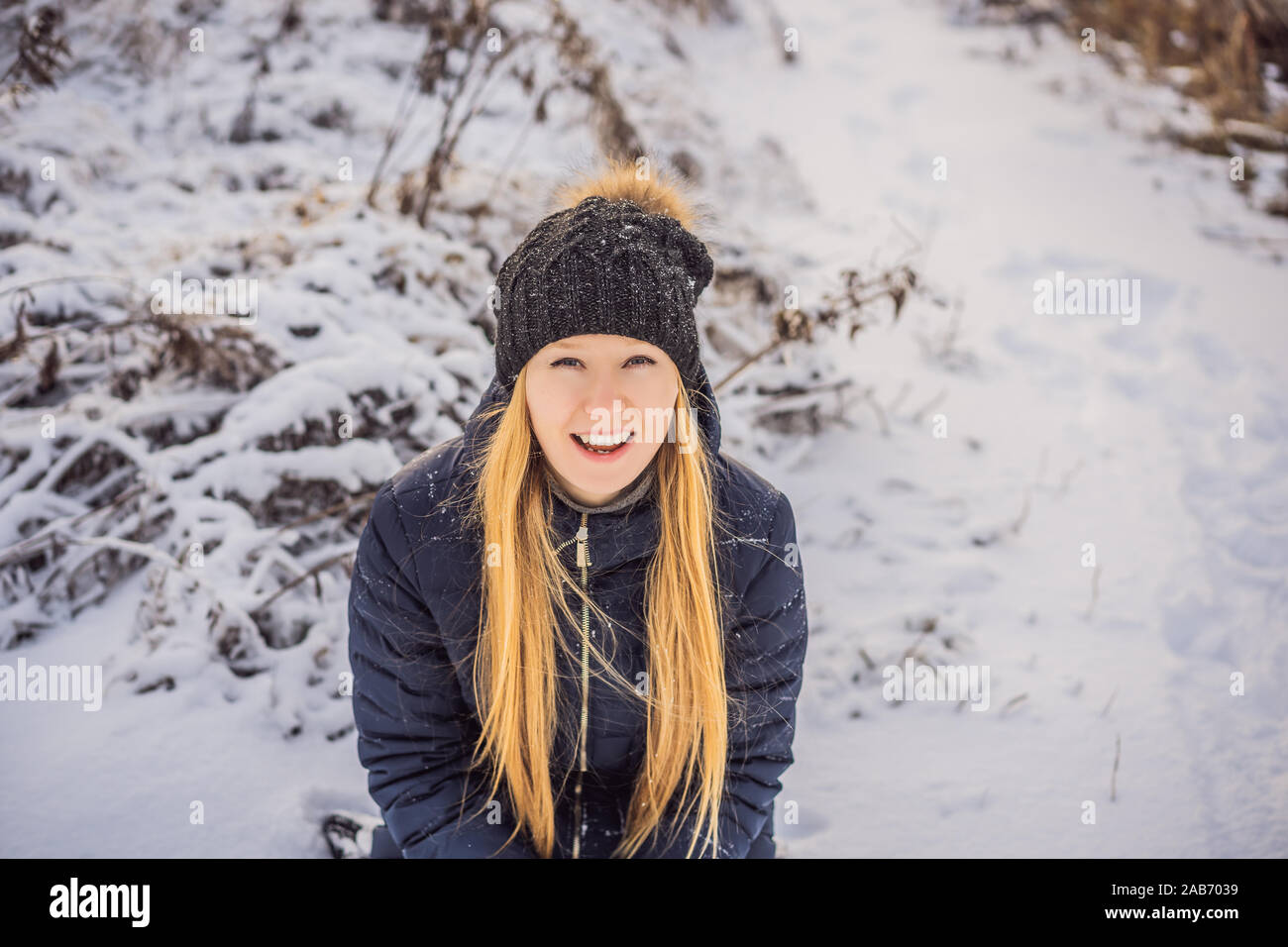 Frau hat Spaß im Winter, wirft Schnee Stockfoto