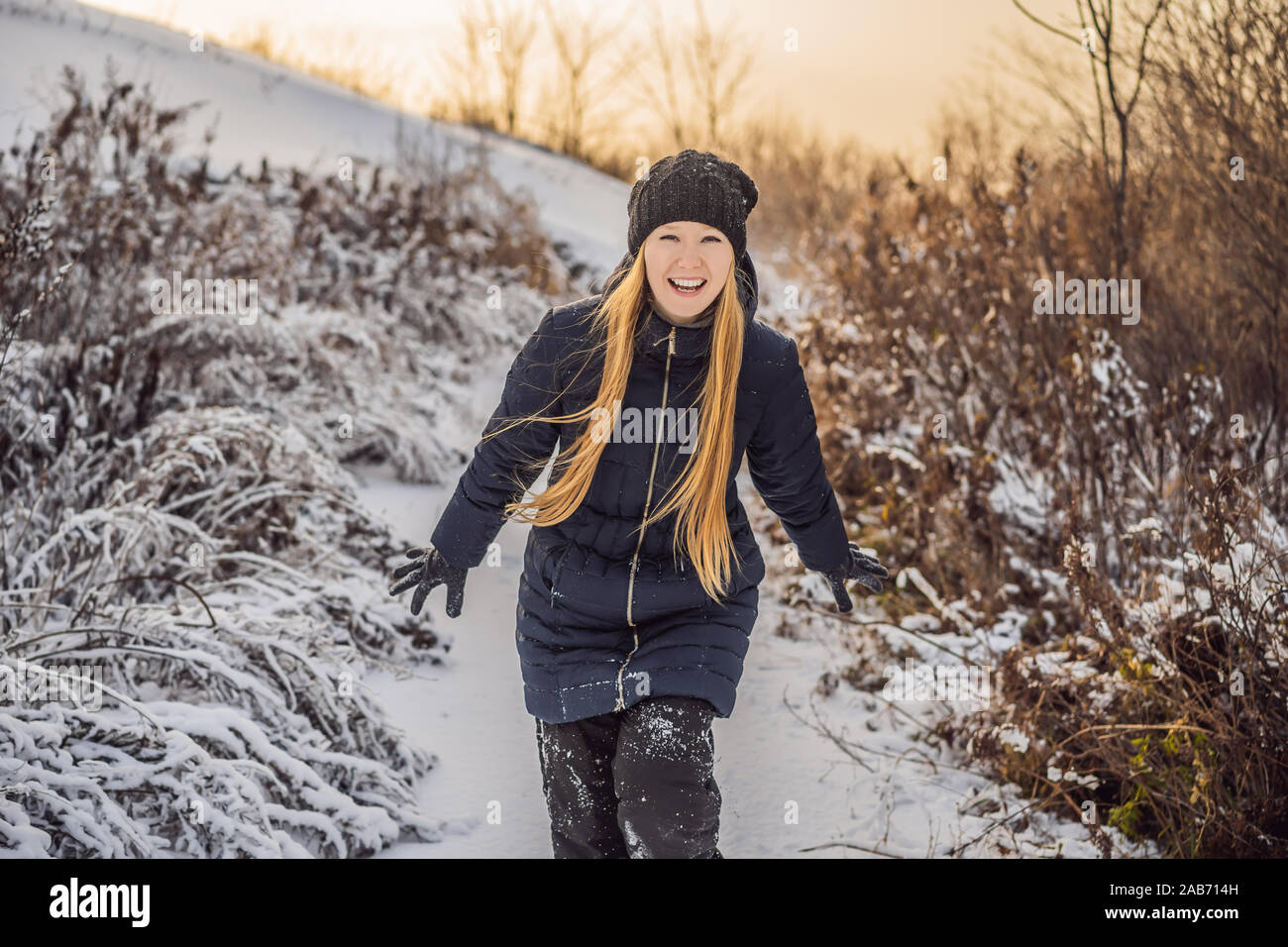 Frau hat Spaß im Winter, wirft Schnee Stockfoto