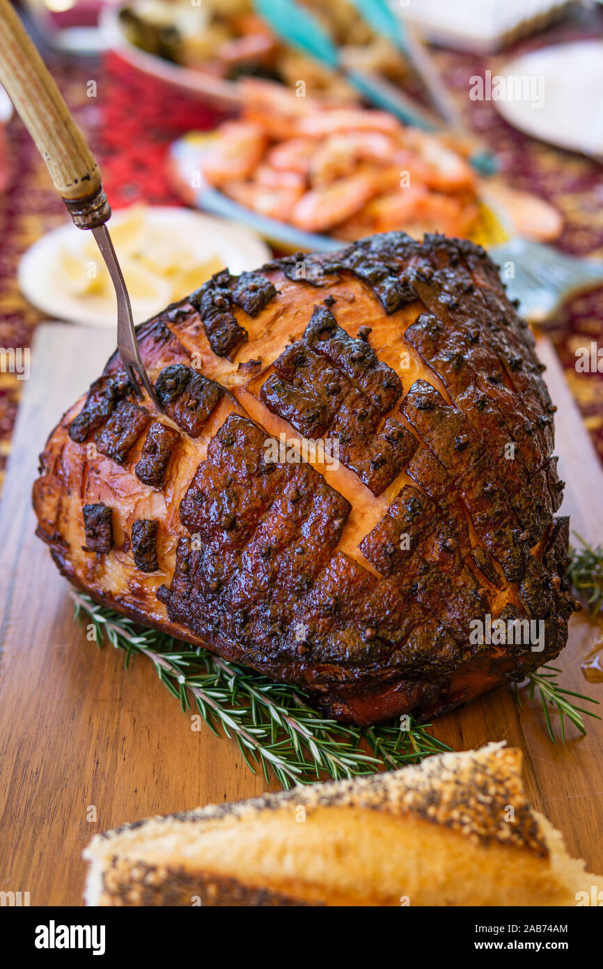 Moderne australische Weihnachtsessen Tabelle mit glasierten Schinken, Garnelen, Hähnchen vom Grill und Salate. Stockfoto