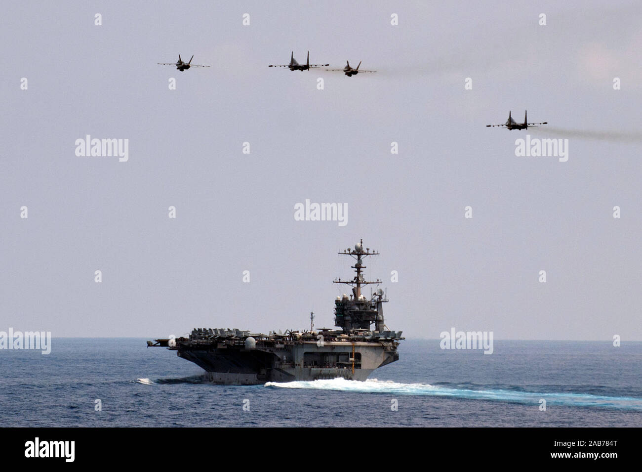 SOUTH CHINA SEA (Okt. 2010) 15, 2012) zwei F/A-18 Super Hornet aus dem Königlichen Streitkolben von Strike Fighter Squadron (VFA) 27 fliegen in Formation mit zwei Royal Malaysian Air Force Suchoi Su-30 s über den Flugzeugträger USS George Washington (CVN 73). Stockfoto