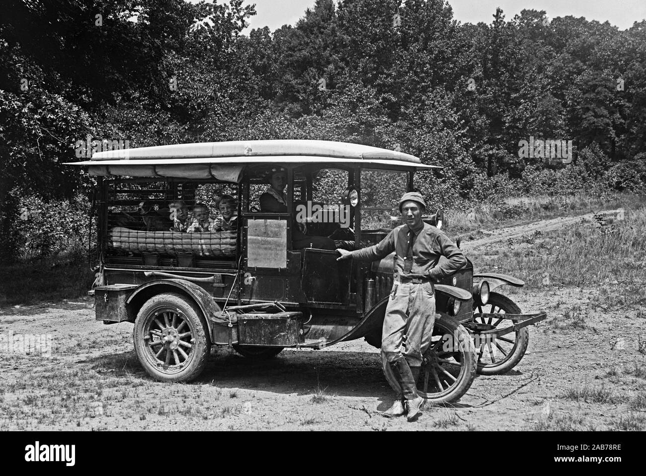 Ein Vater steht vor seinem Auto Camper, während seine Kinder und Frau innen ca bleiben. 1915-1923 Stockfoto