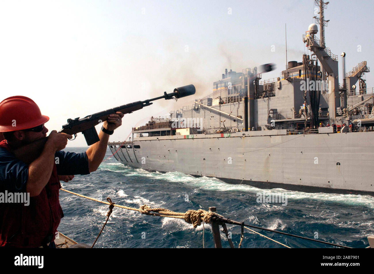 Golf von Oman (Sept. 11, 2012) ist ein Gunner Mate 2. Klasse feuert einen Schuß von der geführten Anti-raketen-Zerstörer USS Nitze (DDG94) auf die militärische Sealift Command schnell bekämpfen Support ship USNS (T-AOE6) während einer Auffüllung auf See. Nitze ist Teil der Enterprise Carrier Strike Group in den USA 5 Flotte Verantwortungsbereich Durchführung Maritime Security Operations, Theater Sicherheit Bemühungen um Zusammenarbeit und Unterstützung für die Operation Enduring Freedom. Stockfoto