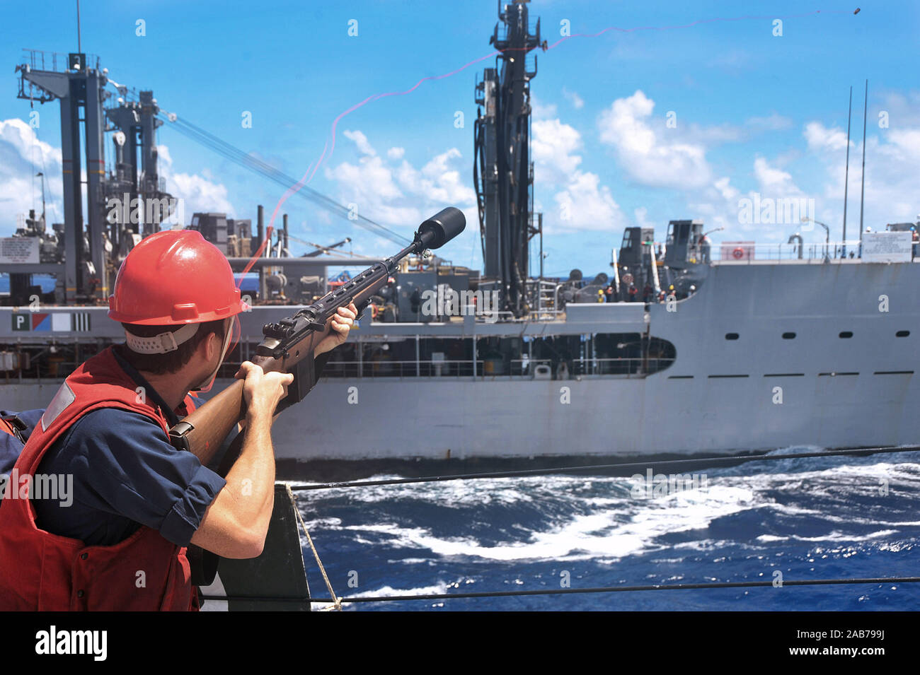 Philippinischen MEER (Aug. 24, 2012) ist ein Gunner Mate 2. Klasse der Arleigh-Burke-Klasse geführte Anti-raketen-Zerstörer USS McCampbell (DDG85), feuert einen Schuß an die militärischen Sealift Command flotte Auffüllung öler USNS Tippecanoe (T-AO 199) während einer Auffüllung auf See. Stockfoto