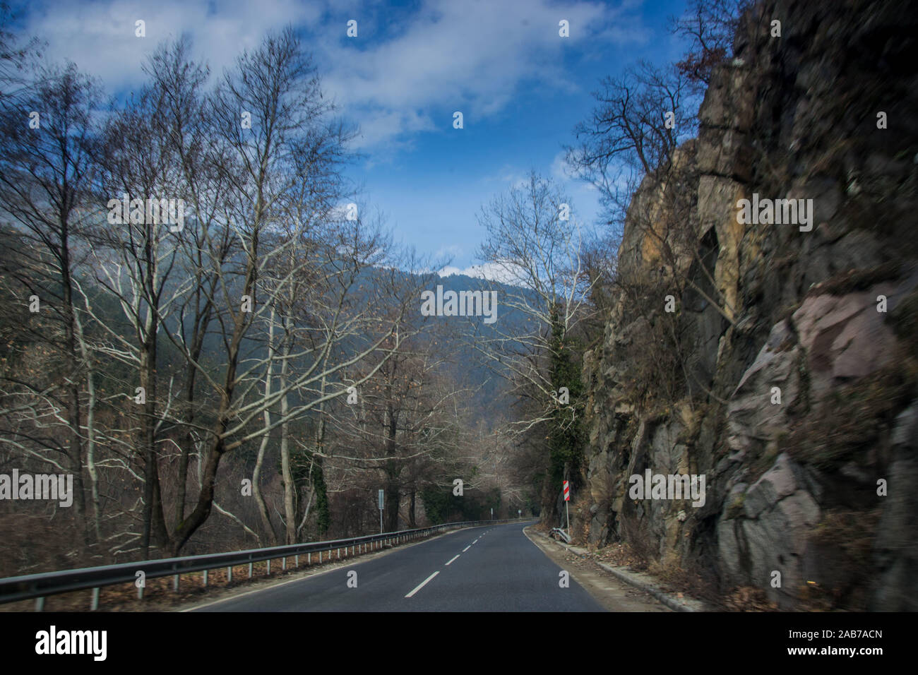 Schönen Bergstraße in Bulgarien, Rhodopi Mountain, Winter auto Straße mit Bäumen und Felsen auf der Seite Stockfoto