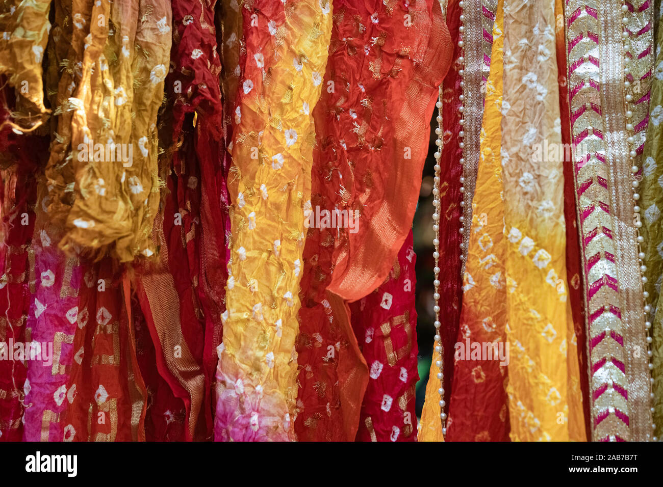 Delhi, Uttar Pradesh, Indien. Bunte Saris und Schals (DUPATTA) hängen in einem street Anzeige der indigenen Handarbeit in Dilli Haat, Delhi, Indien. Stockfoto