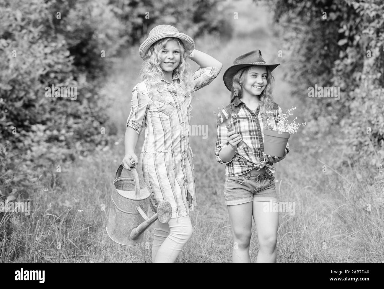 Sie wissen alles über Blumen. kleine Mädchen Bauer im Dorf. Kinder Gartengeräte halten. Feder Land. Tag der Erde. Sommer Familie Bauernhof. Ökologie und Umweltschutz. Stockfoto