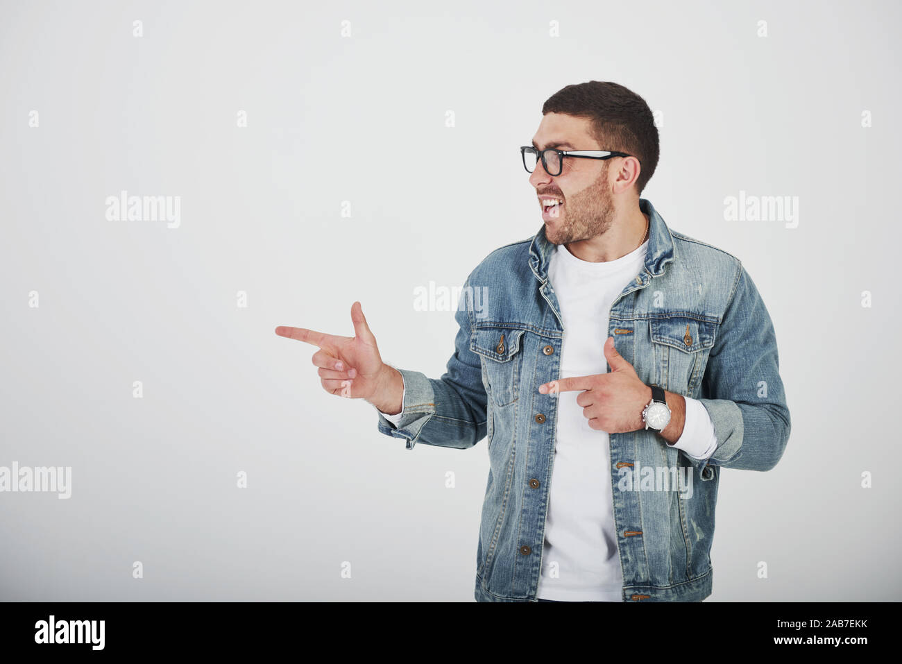 Glücklich, aufgeregt, bärtigen Mann in Brillen an Kamera mit Smile suchen und auf Kopieren Raum mit zwei Fingern isoliert auf weißem Hintergrund Stockfoto
