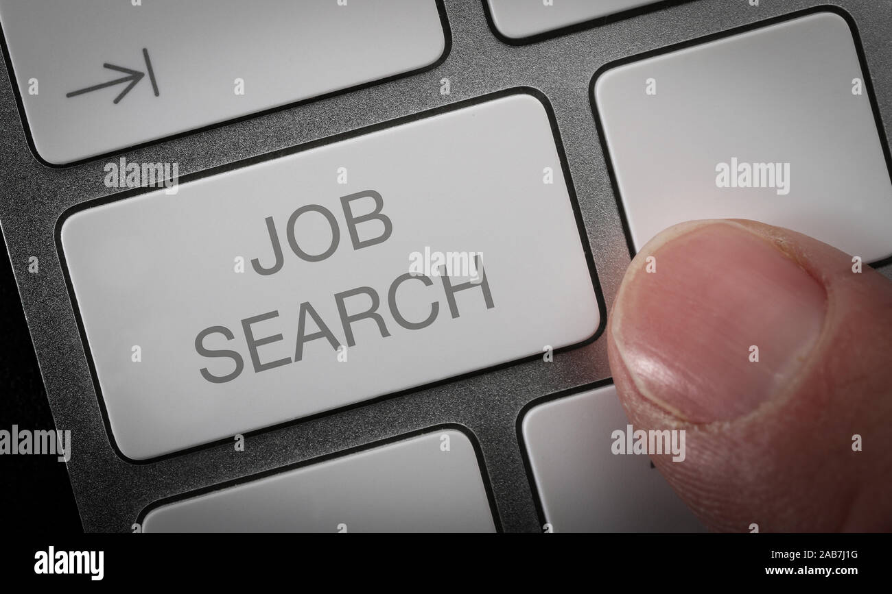 Ein Mann durch Drücken einer Taste auf einer Computertastatur mit den Worten Job suchen. Online Job suche Konzept Bild. Stockfoto