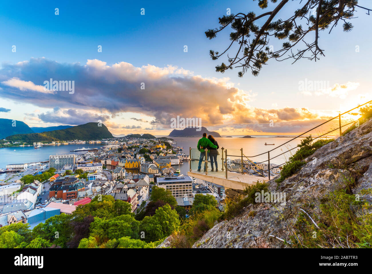 Paar umarmen und genießen den Blick auf Alesund bei Sonnenuntergang von Byrampen Sicht mehr og Romsdal County, Norwegen, Skandinavien, Europa Stockfoto