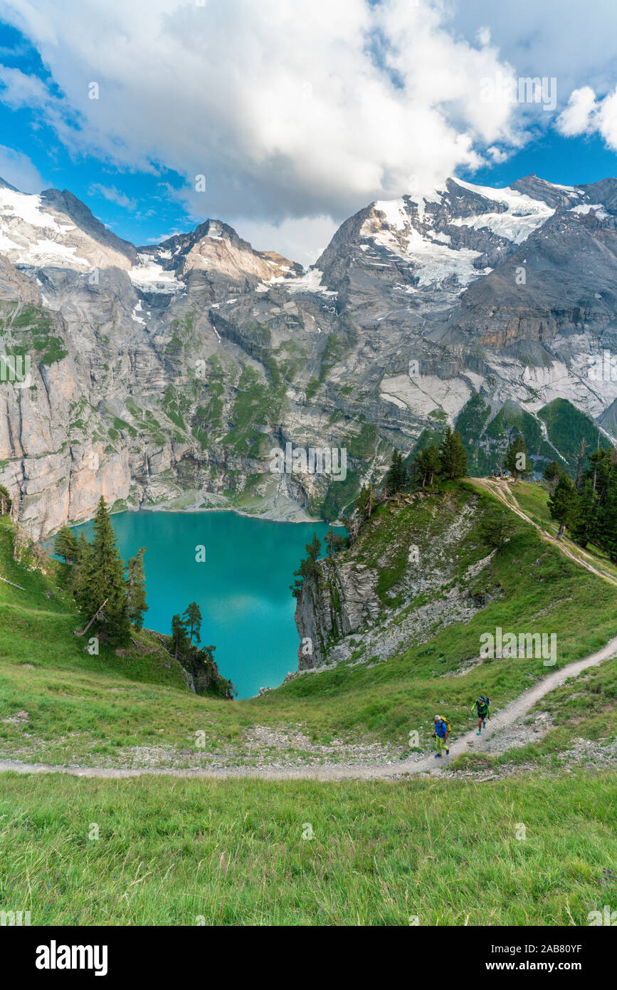 Hohe Betrachtungswinkel von zwei Wanderer zu Fuß auf dem Weg über Oeschinensee See, Berner Oberland, Kandersteg, Kanton Bern, Schweiz, Europa Stockfoto