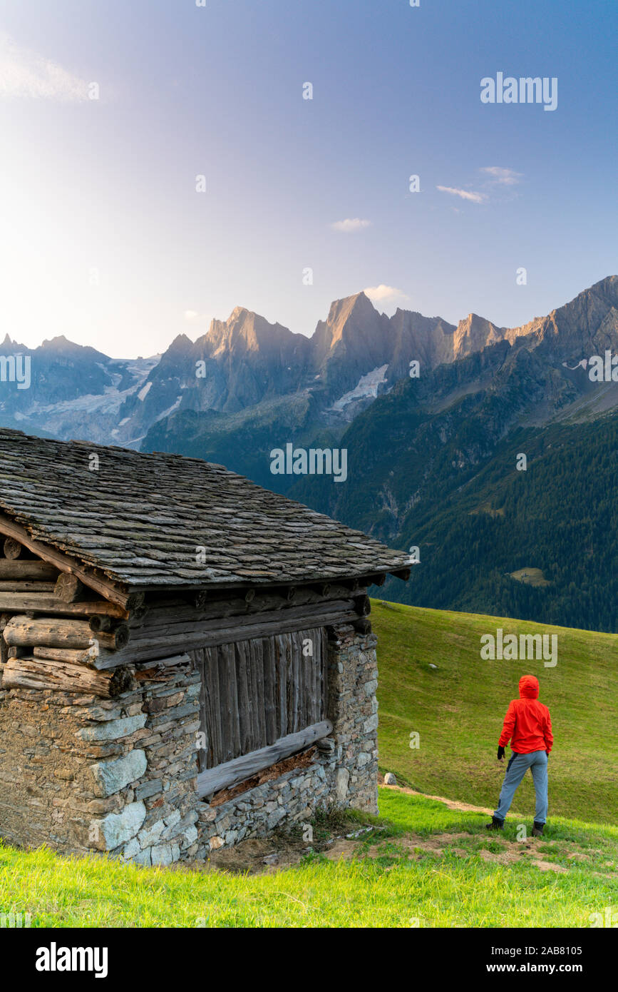 Hintere Ansicht des Mannes aus einer Hütte aus Stein am Piz Cengalo und Badile, Tombal, Val Bregaglia, Kanton Graubünden, Schweiz, Europa suchen Stockfoto