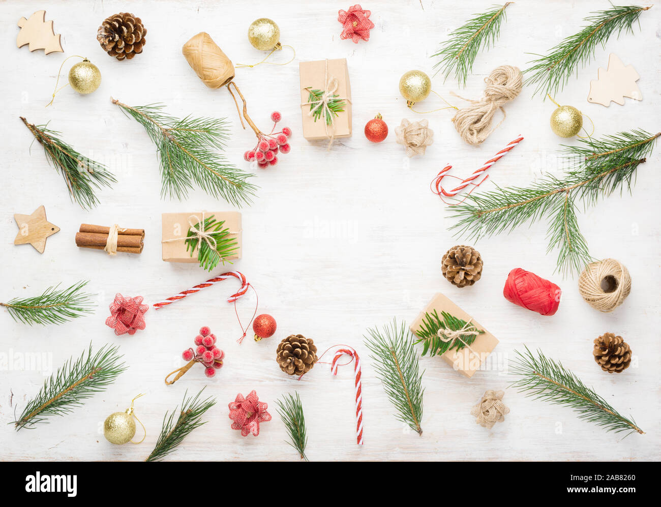 Kreative Weihnachten Hintergrund verschiedener Objekte einschließlich geschenkboxen, Zimtstangen, dekorative Beeren auf weißem Holz- Tabelle, kopieren Raum in der Mitte, am weißen Tisch, selektiver Fokus Stockfoto