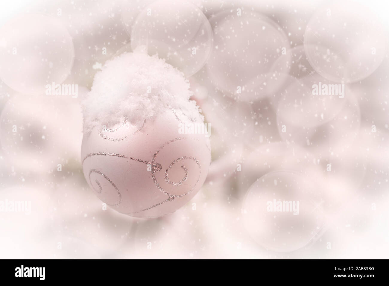 White Christmas Ball mit Schnee bedeckt, verschwommenes Bild Hintergrund, Weihnachten und Urlaubsgrüße Stockfoto