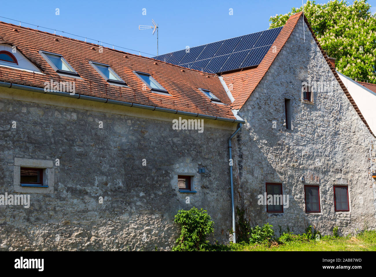 Altes Haus mit Sonnenkollektoren auf dem Dach montiert Stockfoto