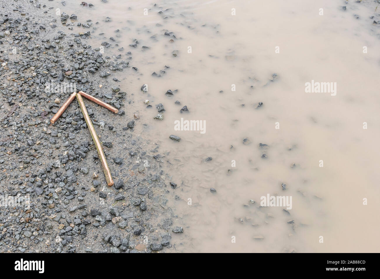 Survival skills Konzept. Signal Pfeil auf Kies' auf diese Weise '/'-Verfahren in dieser Richtung die Richtung der Bewegung oder Position zu zeigen. Stockfoto