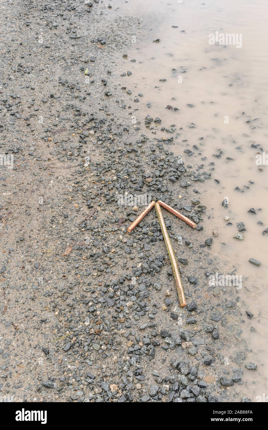 Survival skills Konzept. Signal Pfeil auf Kies' auf diese Weise '/'-Verfahren in dieser Richtung die Richtung der Bewegung oder Position zu zeigen. Stockfoto