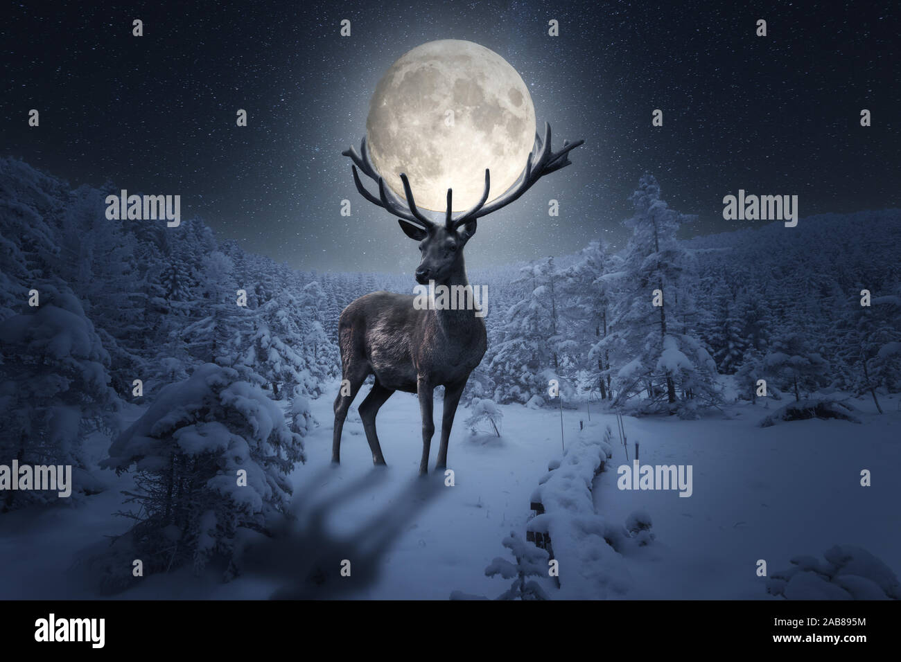 Big deer tragen ein voller Mond auf seinem Geweih in einer verschneiten Winternacht Stockfoto