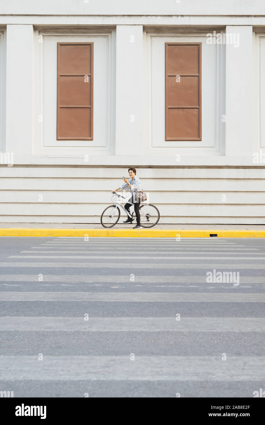 Überall von seinem Fahrrad. Seitenansicht der junge Unternehmer freuen uns auf dem Fahrrad Stockfoto