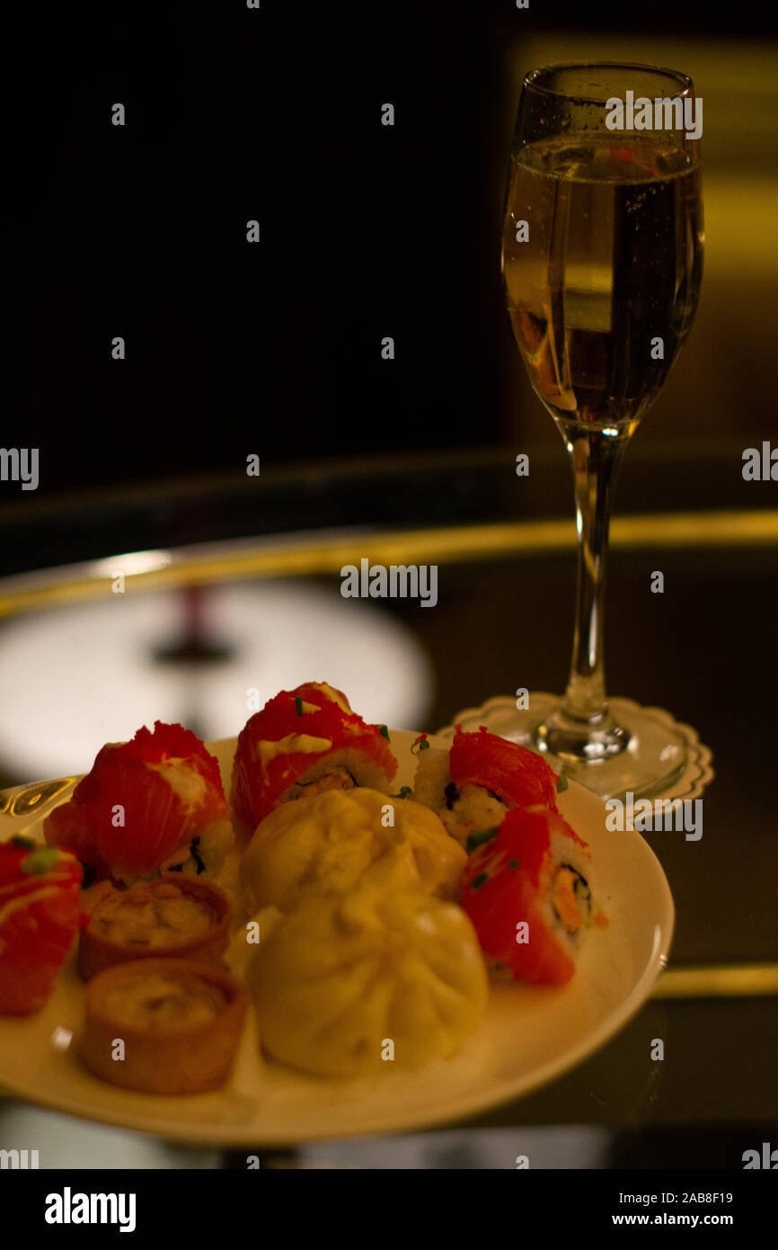 Fizzy Champagner Aperitif vor dem Abendessen Häppchen wie mini Quiches, chinesischen Brötchen und Sushi Stockfoto