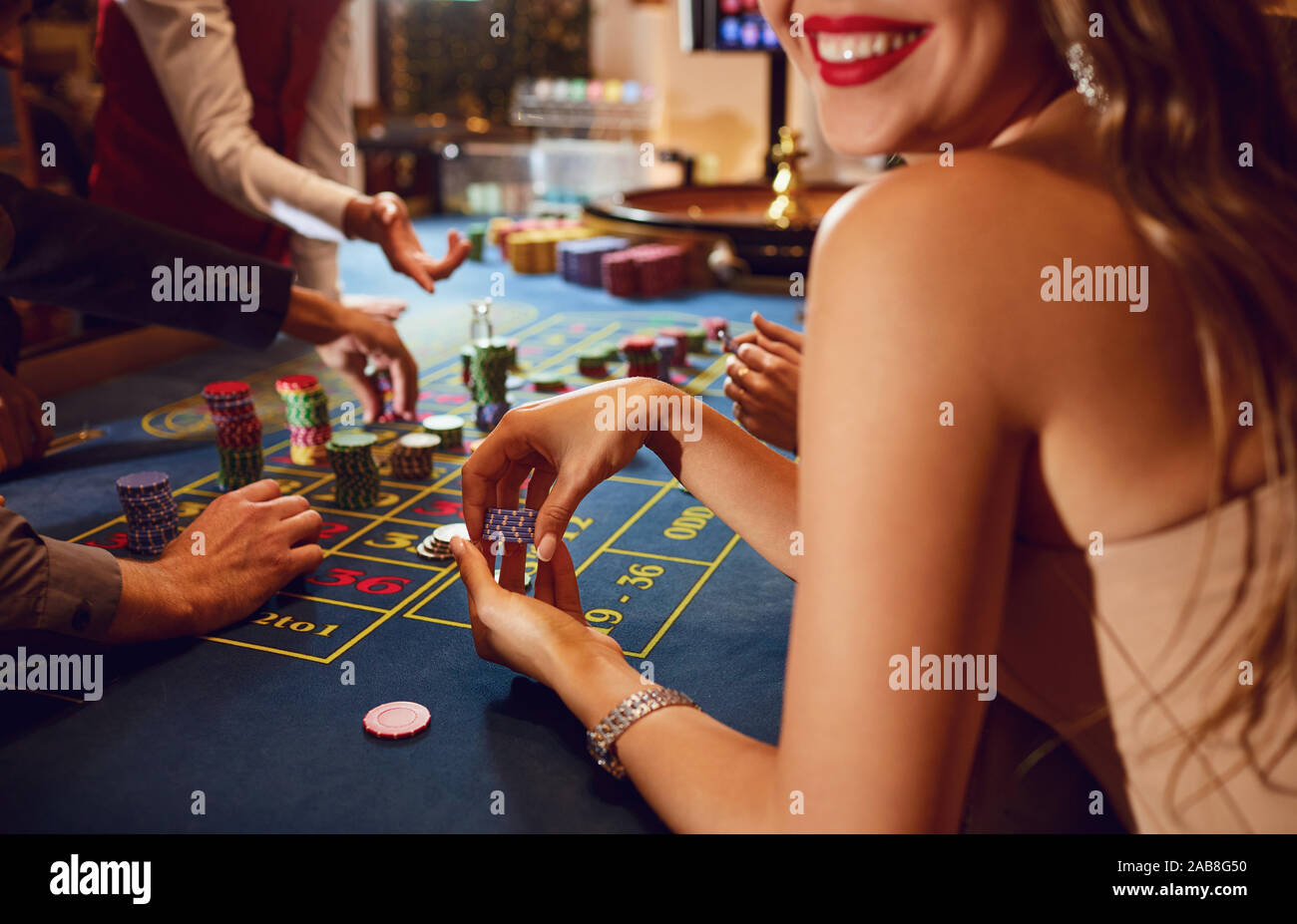 Chips in die Hände eines weiblichen Roulette Spieler im Casino Hintergrund. Stockfoto