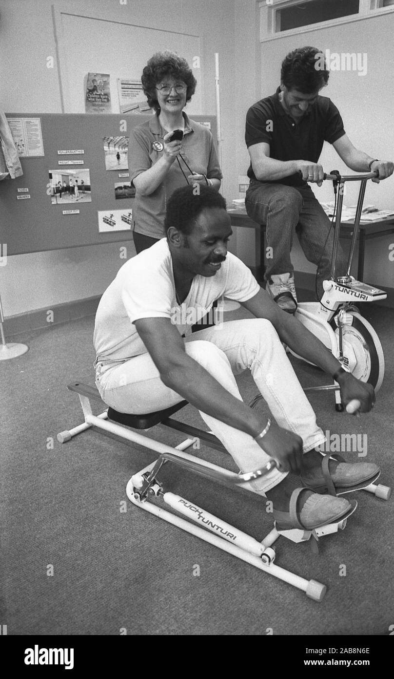 1980 s, historischen, gesund Herz, im Inneren ein Büro, können Sie über  Home Gym kit Personal, ein Rudergerät und einen Heimtrainer, inativive  mployees Gesundheit, England, UK zu verbessern Stockfotografie - Alamy