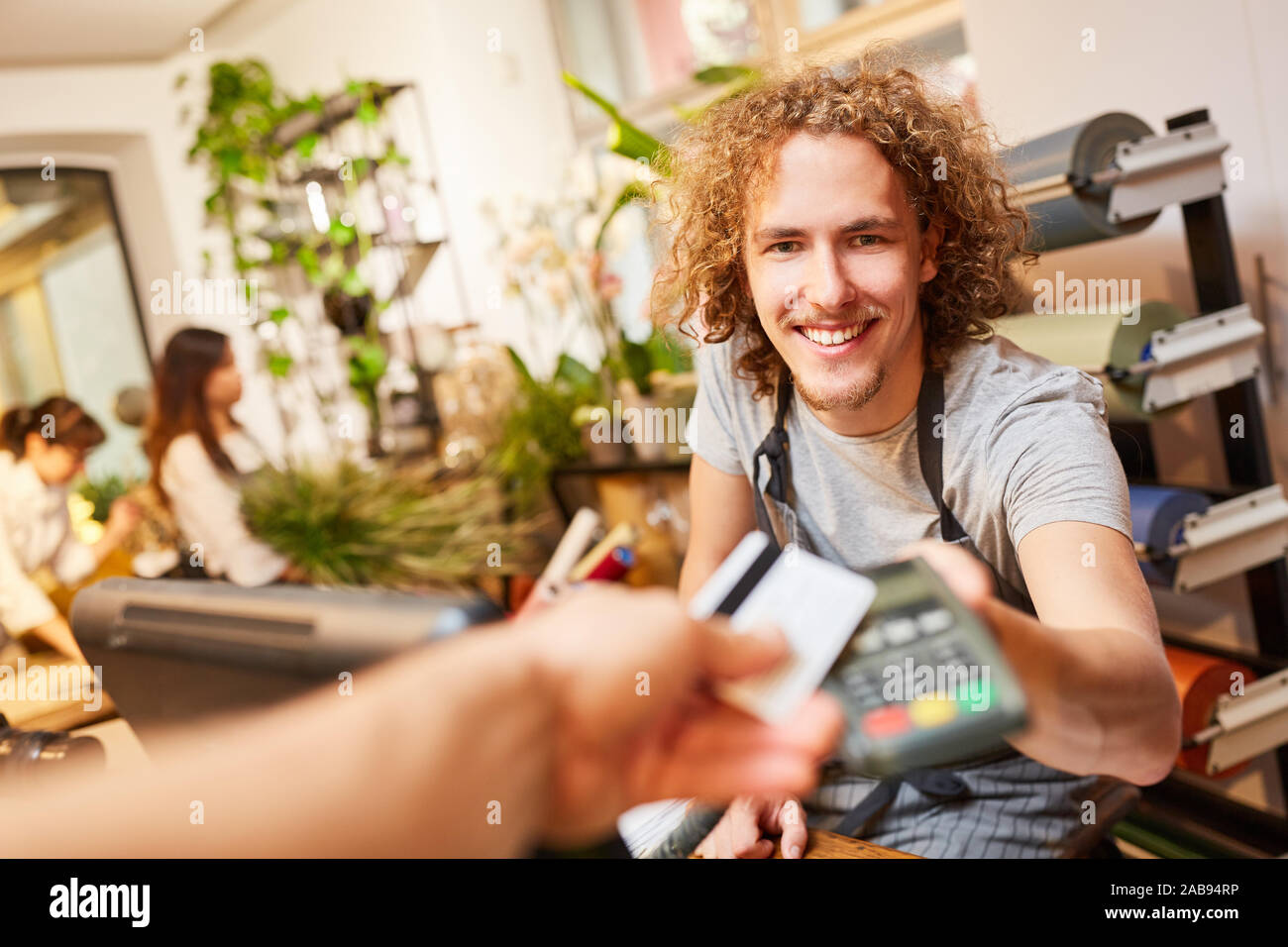 Kunde zahlt mit Kreditkarte an der Kasse im Garten Center Stockfoto