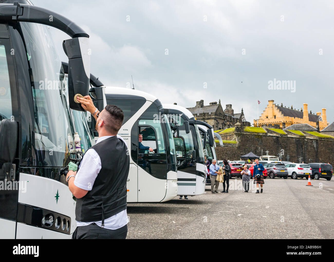 Kraftomnibussen park mit Bus Driver Fensterreinigung, Castle Esplanade, Stirling Castle, Schottland, Großbritannien Stockfoto