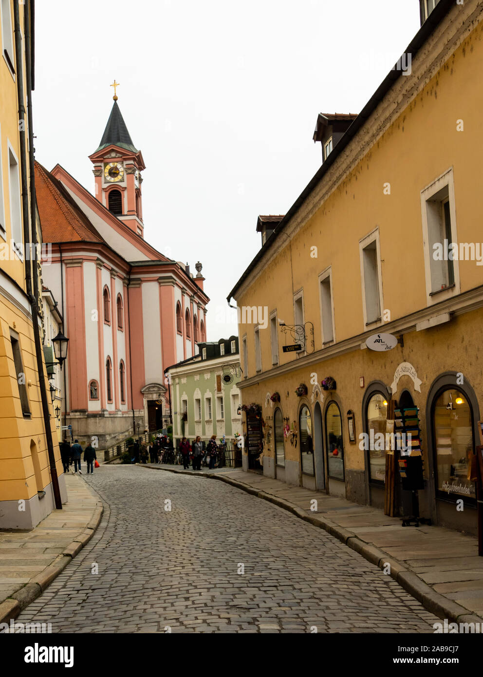 In einer Seitenstraße in der attraktiven Stadt Passau, Deutschland, mit einem Kirchturm im Hintergrund Stockfoto