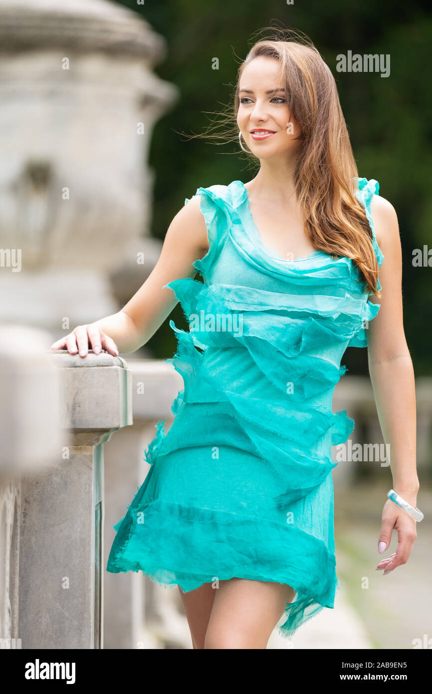 Schöne lächelnde Frau in einem türkis Kleid Stockfoto