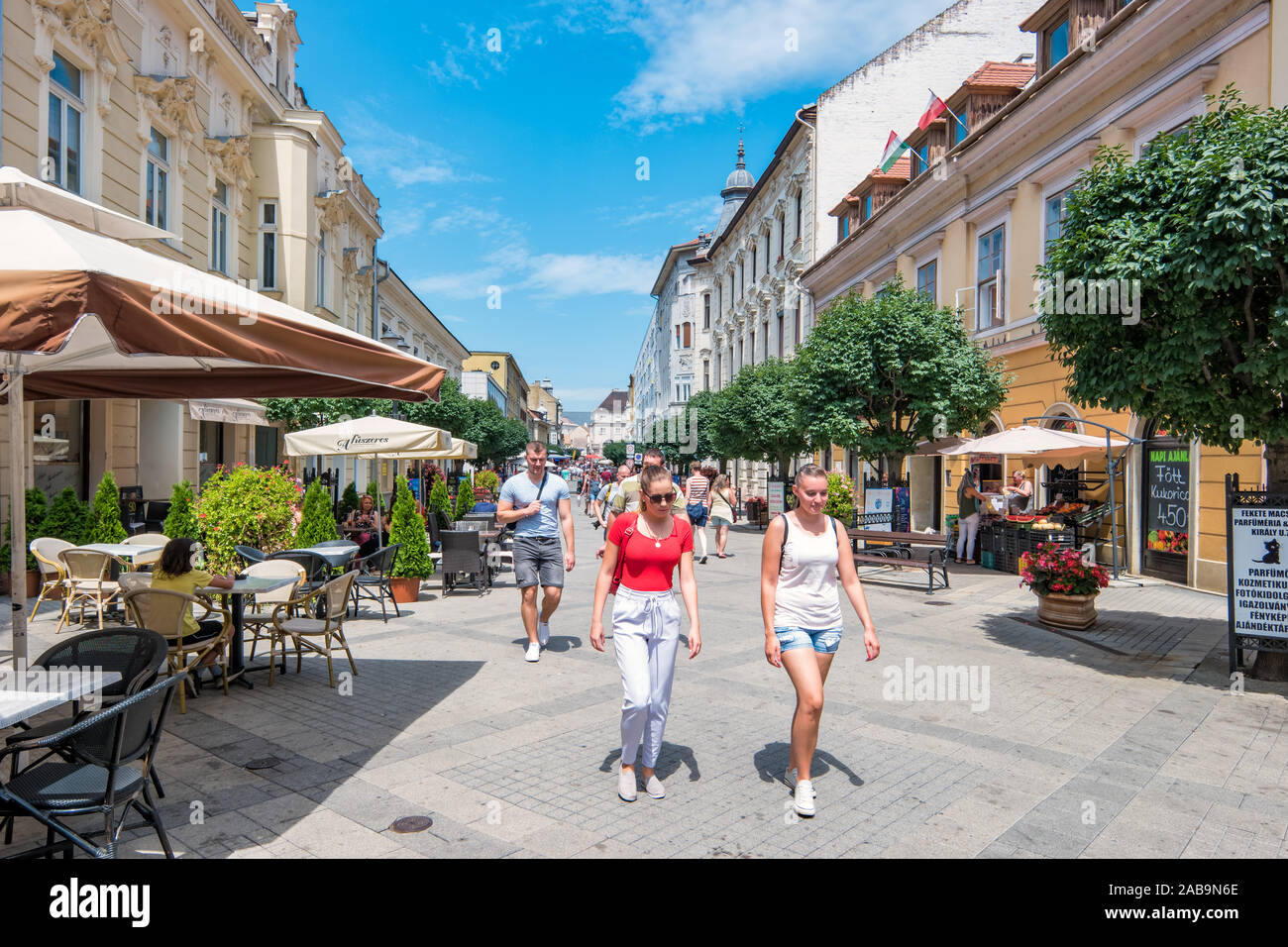 Fußgänger zu Fuß in der Innenstadt von Győr Ungarn an einem sonnigen Tag. Stockfoto