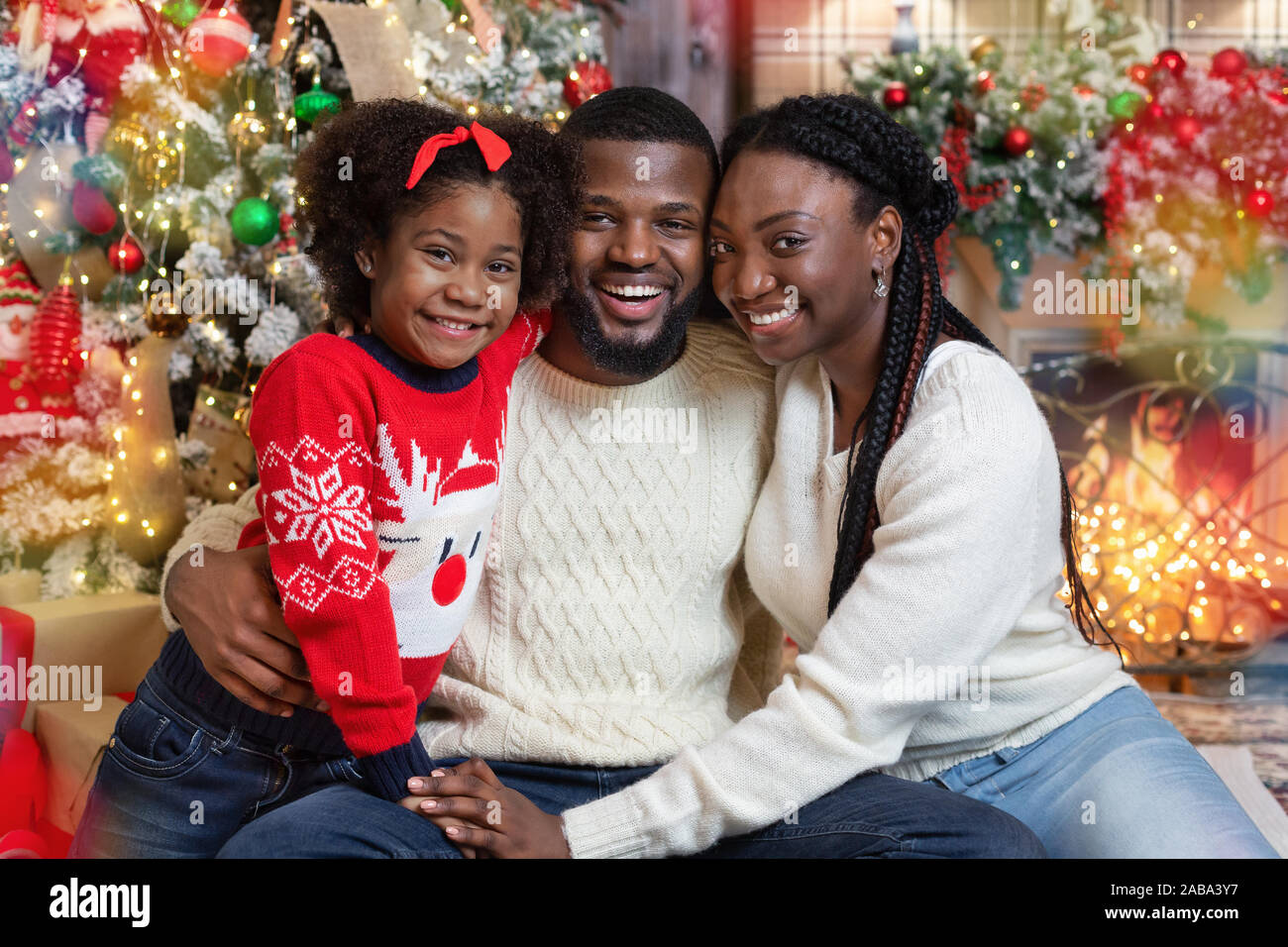 Freudige afrikanische amerikanische Familie von drei in Weihnachten Innenraum posing Stockfoto