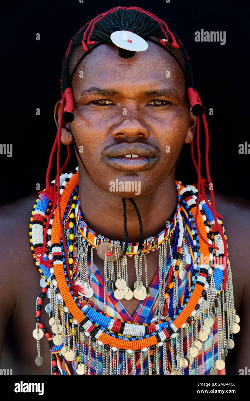 Masai Mann mit traditionellen Raupe Arbeit und Farbe Glas geschmückt Perlen um den Hals. Masai Mara National Reserve, Kenia. Stockfoto
