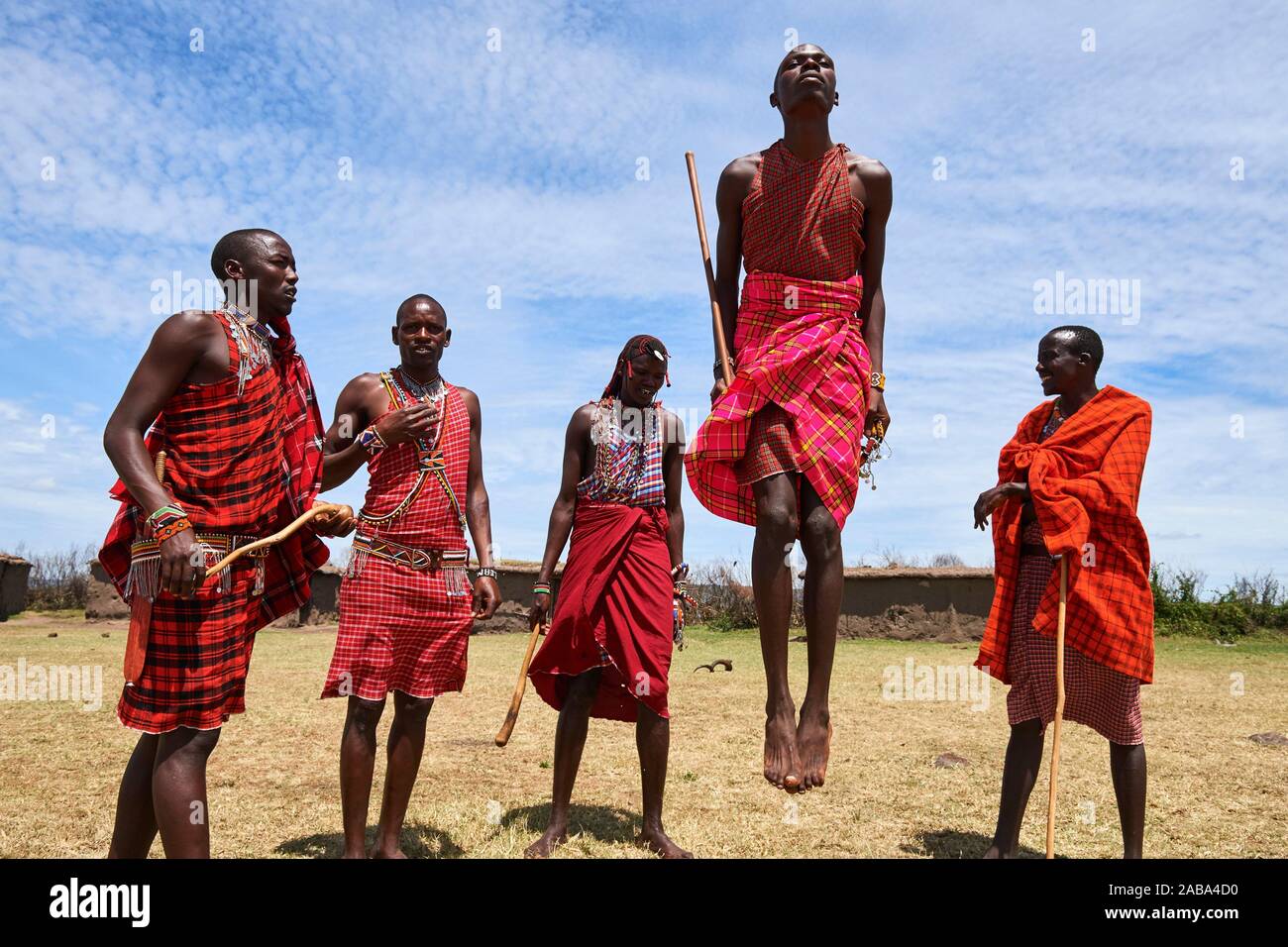 Junge Maasai Männer Durchführen einer traditionellen springen Tanz, Masai Mara National Reserve, Kenia. Stockfoto