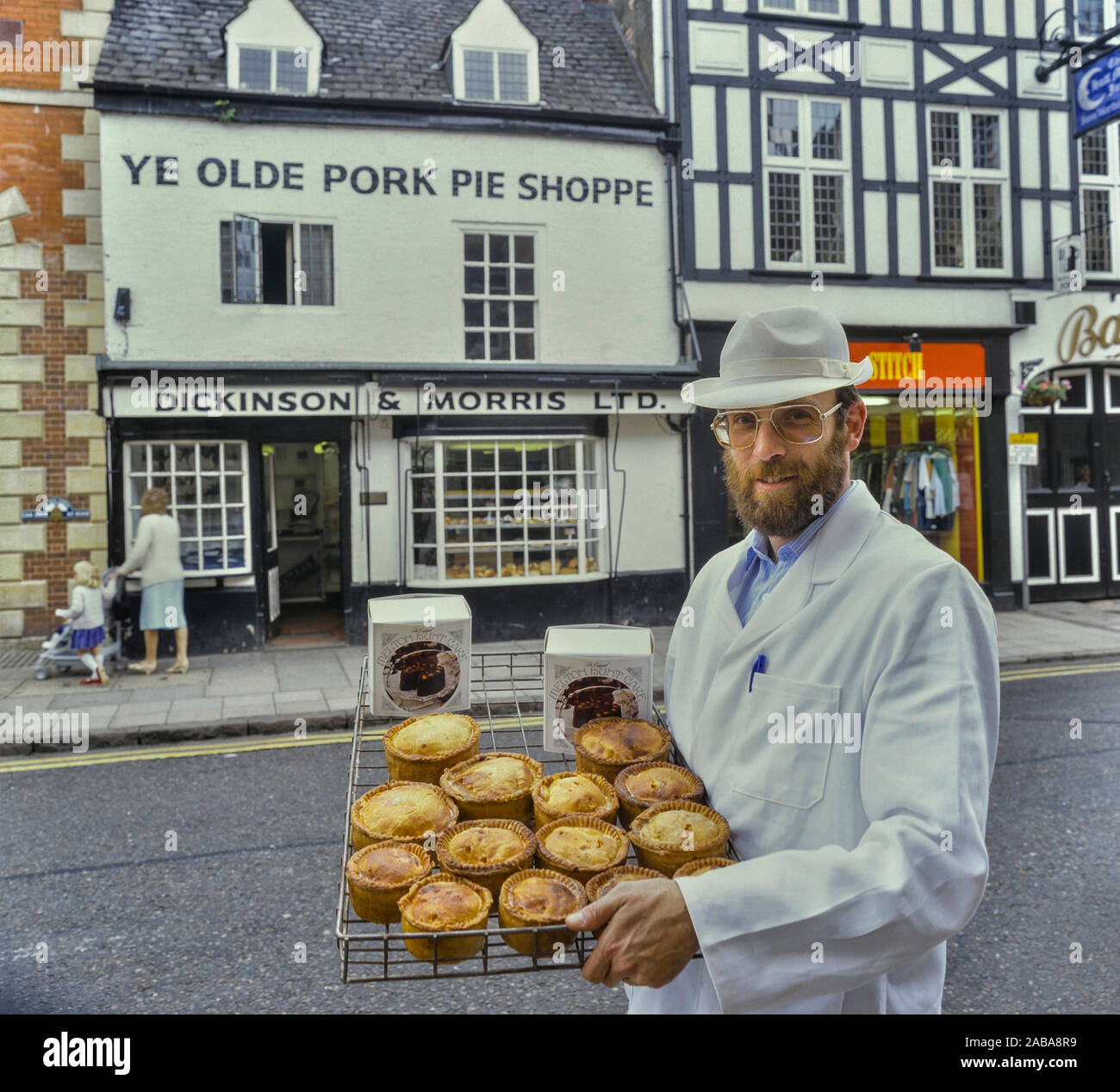Ein Bäcker hält ein Tablett mit Melton Mowbray Schweinefleischpasteten & Melton Jagd Kuchen. Ye Olde Shoppe Pork Pie. Melton Mowbray. Leicestershire. Stockfoto