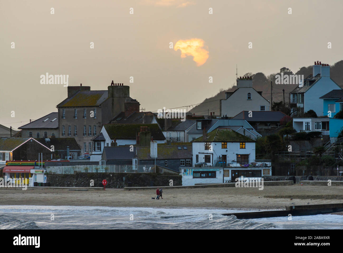 Lyme Regis, Dorset, Großbritannien. 26 Nov, 2019. UK Wetter. Die Sonne teilweise verdeckt von Wolken über dem Meer bei Sonnenuntergang in Lyme Regis in Dorset am Ende des bedeckten und stürmischer Tag. Foto: Graham Jagd-/Alamy leben Nachrichten Stockfoto