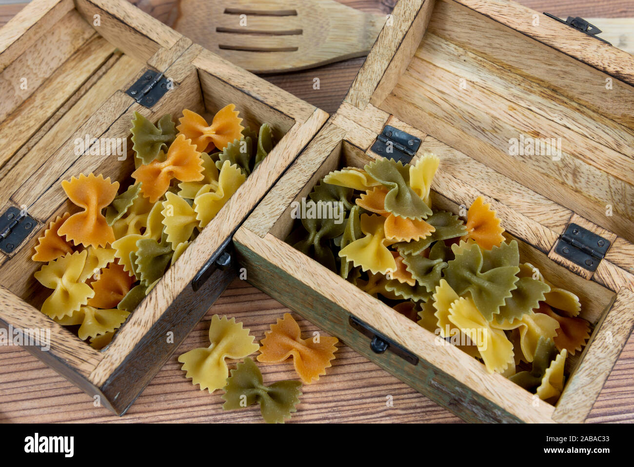 Tricolore farfalle rohe Nudeln und Holzbox Stockfoto