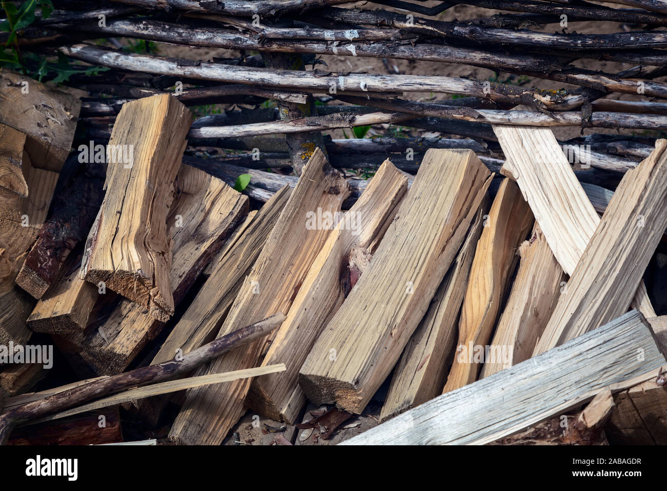 Ein Haufen von Holz in der Nähe eines Wicker Zaun Stockfoto