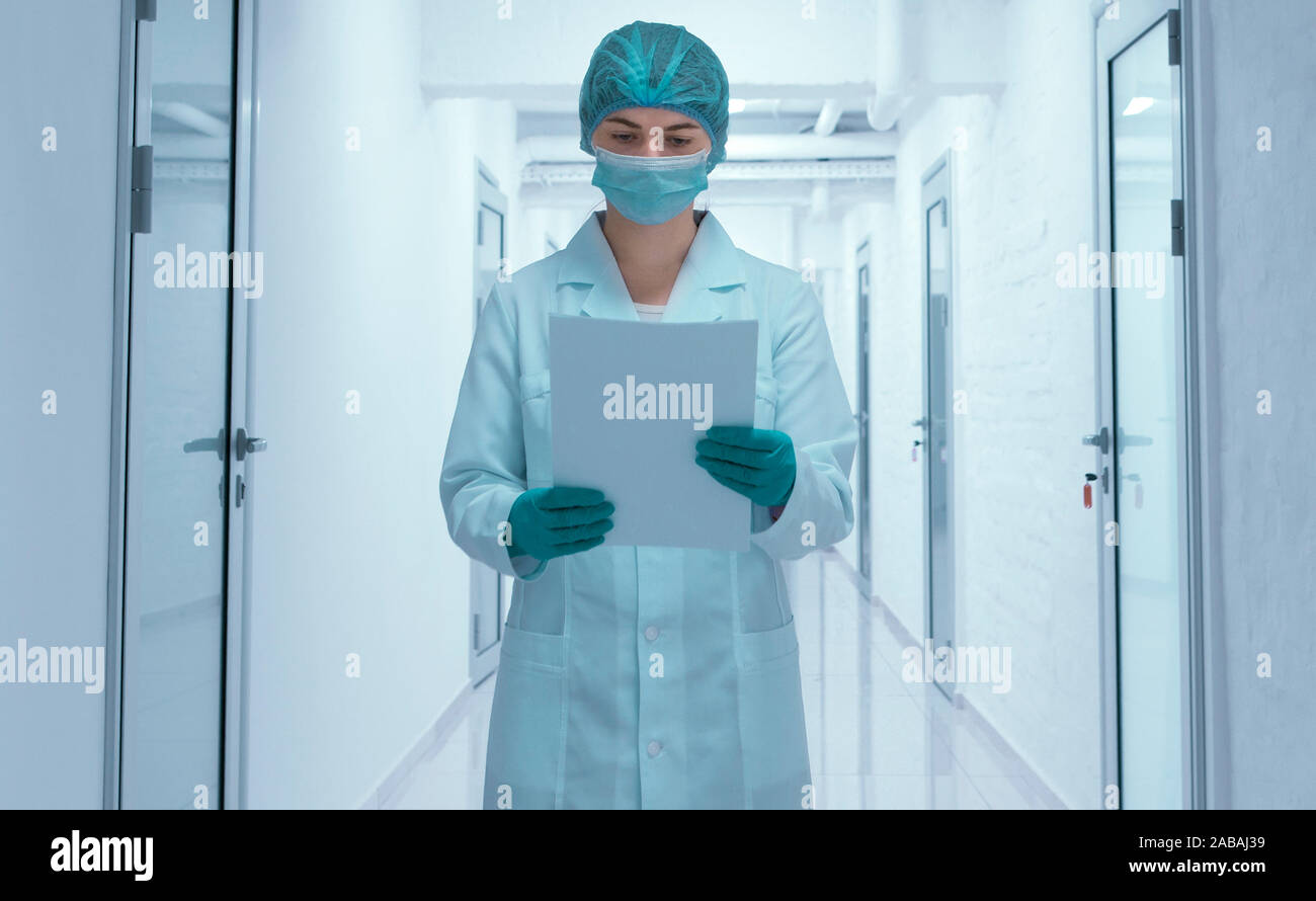 Frau in der medizinischen Verschleiß auf Dokumente Stockfoto